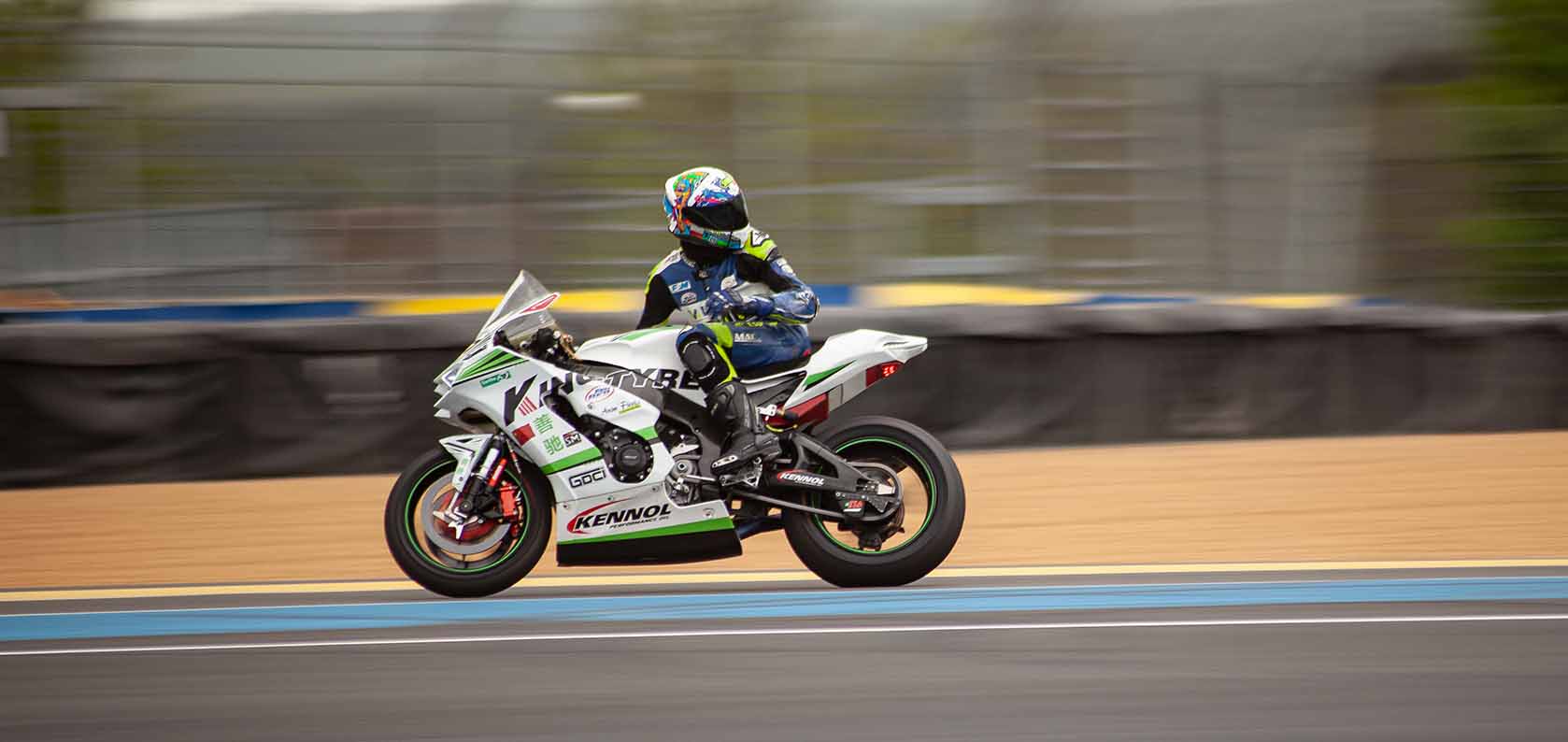 Professional motorcycle racer leaning into a corner with Kingtyre racing slick tires.