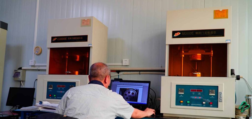 Kingtyre engineers testing racing tire rubber compounds in a laboratory.